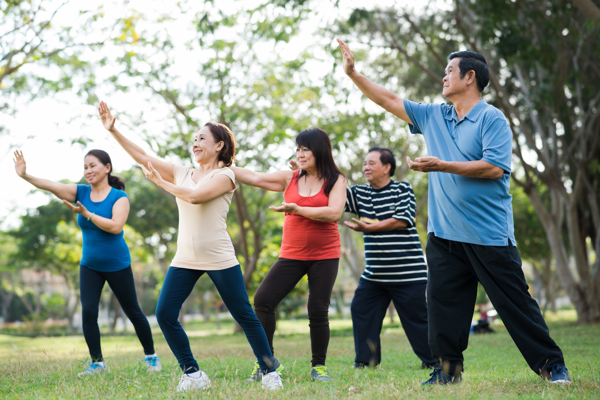 Group of adults practicing tai chi together outdoors